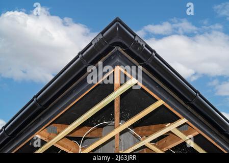 Gerüst mit drei Reihen von Holzlatten zur Befestigung der PVC-Soffit, sichtbare Kabel für die Beleuchtung. Stockfoto