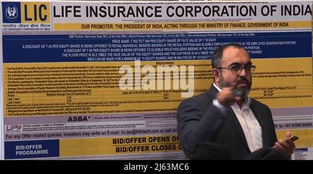 Mumbai, Indien. 27. April 2022. Während einer Pressekonferenz in Mumbai wird ein Mann neben dem Poster der Life Insurance Corporation of India (LIC) gesehen. Das erste öffentliche Angebot (IPO) wird am 4.. Mai 2022 öffentlich abonniert. (Foto von Ashish Vaishnav/SOPA Images/Sipa USA) Quelle: SIPA USA/Alamy Live News Stockfoto