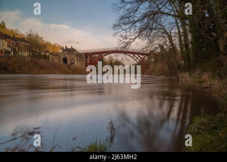 Die Eiserne Brücke über den Fluss Severn während einer Zeit hoher Überschwemmungen, Ironbridge Gorge im Stadtteil Telford und Wrekin in Shropshire, England. Stockfoto