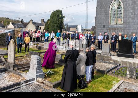 Dunmanway, West Cork, Irland. 27. April 2022. Heute ist der 100.. Jahrestag der Tötungen im Bandon Valley, bei denen 3 Männer aus Dunmanway getötet wurden. Der Bischof von Cork, Cloyne und Ross, Dr. Paul Colton, betet, nachdem er einen Kranz auf das Grab des 37-jährigen Opfers David Gray gelegt hat. Quelle: AG News/Alamy Live News Stockfoto