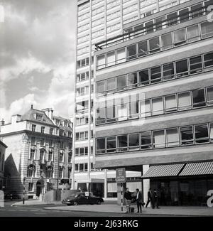 1960s, dem historischen Zentrum Londons und dem Äußeren eines der vielen neuen modernen Büro- und Hotelgebäude, die in den Nachkriegsjahren erbaut wurden. Hoch und rechteckig, aus vorgegossenem Beton mit außerhalb des Standorts gebauten Fensterpaneelen gebaut, waren diese „modernen“ Gebäude schneller und kostengünstiger zu bauen als die traditionellen Ziegelbauten. Am Eingang zum St. George's Hotel am Langham Place, dem Bewohner des Gebäudes, ist ein Jaguar der damaligen Zeit zu sehen. Stockfoto