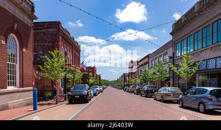 GREER, SC, USA 24. APRIL 2022: Weitwinkelansicht der Trade Street am sonnigen Frühlingstag. Zwei Personen gehen. Stockfoto