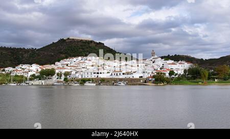 Blick von Alcoutim in Portugal über den Fluss Guadiana nach Sanlúcar de Guadiana in Spanien, typische Grenzstadt mit weißen Häusern und mittelalterlicher Burg, Alg Stockfoto