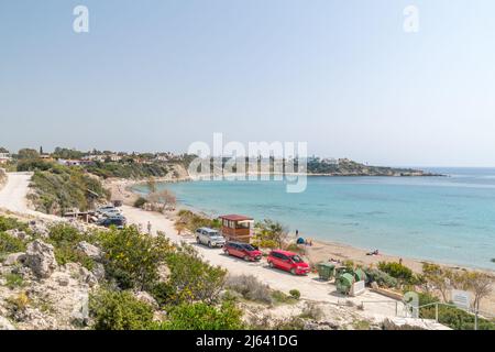 Peyia, Zypern - 2. April 2022: Panoramablick auf den Sandstrand von Coral Bay an sonnigen Tagen. Stockfoto