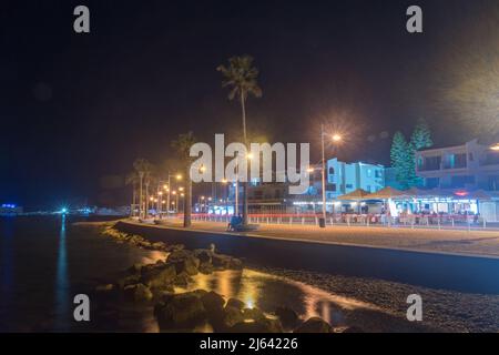 Paphos, Zypern - 2. April 2022: Uferpromenade und Touristenallee am Mittelmeer in der Nacht. Stockfoto