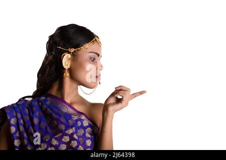Ein indisches Mädchen, das einen traditionellen indischen blauen Saree und einfachen Schmuck trägt Stockfoto