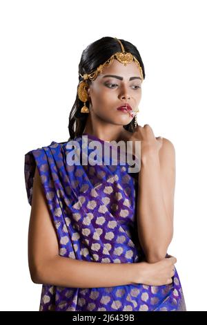 Ein indisches Mädchen, das einen traditionellen indischen blauen Saree und einfachen Schmuck trägt Stockfoto