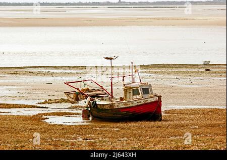LYTHAM. LANCASHIRE. ENGLAND. 01-05-13. Ein rot geschältes Fischerboot wartet am Ufer auf die nächste Flut. Stockfoto