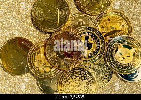 Goldene Krypto-Münzen auf goldenem Hintergrund. Bitcoin Kryptowährung mit Altmünzen und Shitcoins. Hochwertige Fotos Stockfoto