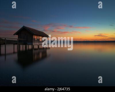 Die Seebrücke am ammersee in deutschland, beleuchtet von den Lichtern des Sonnenuntergangs Stockfoto