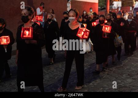 Frauen, die trauern, halten eine Prozession bei Kerzenschein durch die Straßen zur Feier des Karsamstags, 16. April 2022 in Patzcuaro, Michoacan, Mexiko. Die kleine indigene Stadt bewahrt die Traditionen der spanischen Kolonialherrschaft, einschließlich der Bruderschaft der Büßer während der Karwoche. Stockfoto