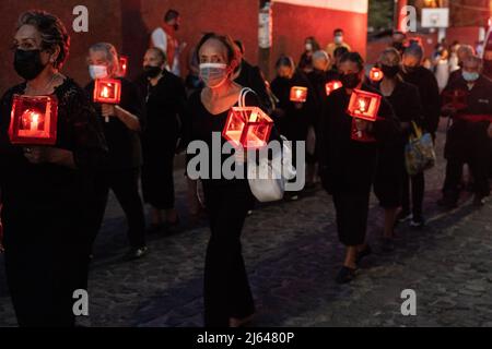 Frauen, die trauern, halten eine Prozession bei Kerzenschein durch die Straßen zur Feier des Karsamstags, 16. April 2022 in Patzcuaro, Michoacan, Mexiko. Die kleine indigene Stadt bewahrt die Traditionen der spanischen Kolonialherrschaft, einschließlich der Bruderschaft der Büßer während der Karwoche. Stockfoto