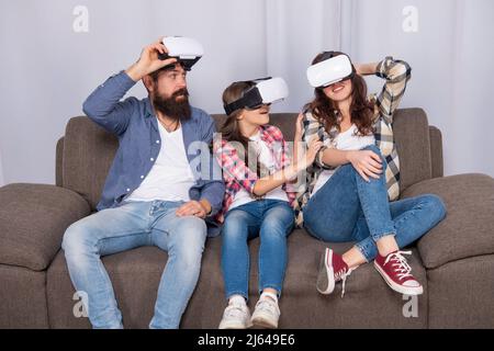 Staunende Familie tragen vr Gläser sitzen auf dem Sofa zu Hause, Videospiel Stockfoto