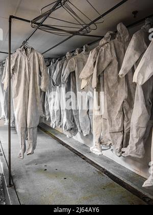 Zum Trocknen hängende Gefahrgut-Anzüge Stockfoto