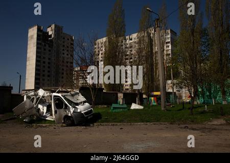 Charkiw, Ukraine. 26. April 2022. Ein zerstörtes Fahrzeug ist nach einem früheren russischen Beschuss in einem Wohngebiet in Charkiw, Ukraine, am 26. April 2022 sichtbar. Damit nicht drei Zivilisten getötet und vier verletzt wurden, indem russische Beschuss die Stadt beschossen hat. Russland hat mit einer „doppelten Zapfenmethode“ beschossen, was bedeutet, dass Russland den gleichen Ort oft innerhalb von 20-30 Minuten beschossen hat und am zuvor getroffenen Ort Menschen wie Sanitäter und Feuerwehrleute verletzt oder getötet hat. (Bild: © Daniel Carde/ZUMA Press Wire) Bild: ZUMA Press, Inc./Alamy Live News Stockfoto