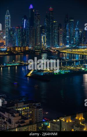 Dubai, VAE - 05 2021. Dez.: Luftaufnahme der Wolkenkratzer der Dubai Marina bei Nacht, aufgenommen vom Aura Skypool. Tapete mit Blick auf die Stadt bei Nacht in Dubai Stockfoto