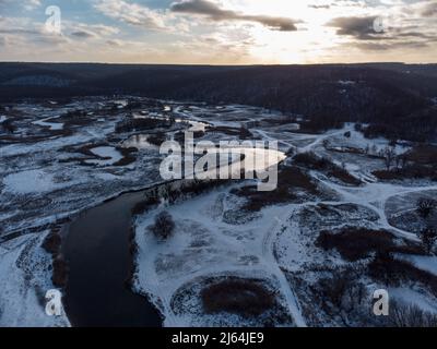 Winter Luftaufnahme ländlichen epischen Blick auf verschneiten Flusstal von Drohne. Region Smijewski auf dem Fluss Siwerskyi Donez in der Ukraine. Kontrast Flusskurve unter Sonne Stockfoto