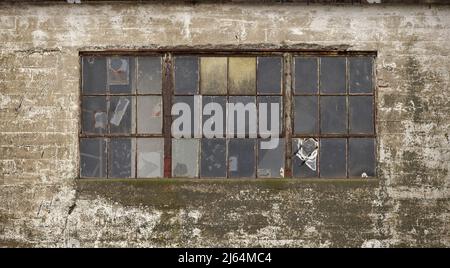 Alte zerbrochene Fenster auf einem alten Industriekornsilo Stockfoto