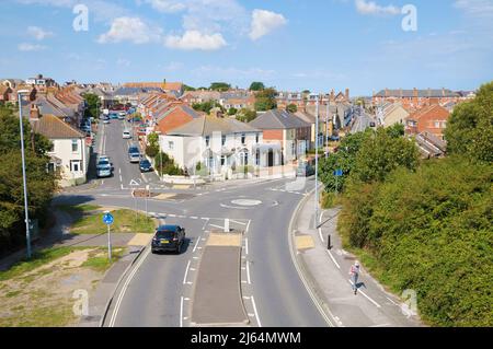 Erhöhter Blick auf Wohnstraßen und Doppelhaushälften mit Mini-Kreisverkehr und Straßenkreuzung am Stadtrand von Weymouth, Dorset, England, Großbritannien Stockfoto