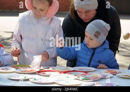 Olaine, Lettland - 18. April 2022. Kreative Malwerkstatt für eine Familie. Mama mit Kind malen mit Farben. Eine Outdoor-Szene in der Frühjahrssaison bei E Stockfoto