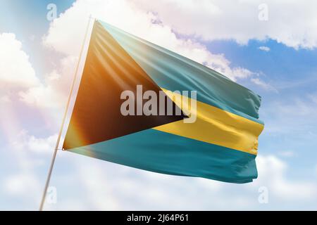 Sonniger blauer Himmel und ein Fahnenmast mit der Flagge der bahamas Stockfoto