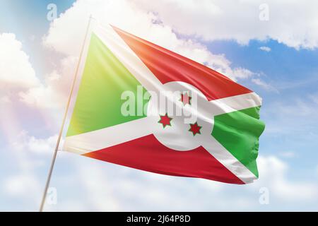 Sonniger blauer Himmel und ein Fahnenmast mit der Flagge burundis Stockfoto