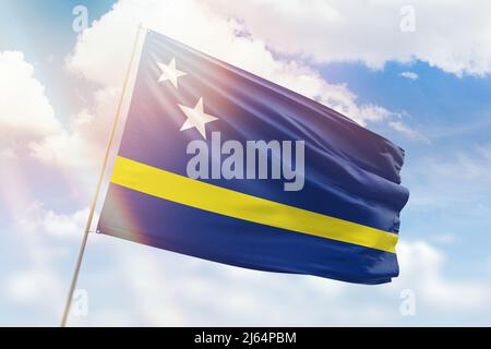 Sonniger blauer Himmel und ein Fahnenmast mit der Flagge von curacao Stockfoto