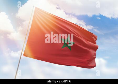 Sonniger blauer Himmel und ein Fahnenmast mit der Flagge marokkos Stockfoto