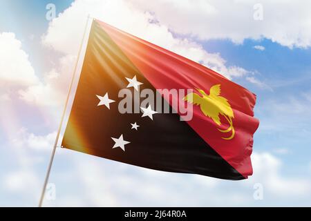 Sonniger blauer Himmel und ein Fahnenmast mit der Flagge der papua-Neuguinea Stockfoto