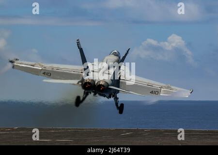 PHILIPPINISCHE SEE (25. April 2022) eine F/A-18E Super Hornet, die den „Vigilantes“ des Strike Fighter Squadron (VFA) 151 zugewiesen wurde, startet vom Flugdeck des Nimitz-Klasse-Flugzeugträgers USS Abraham Lincoln (CVN 72) aus. Die Abraham Lincoln Strike Group befindet sich im geplanten Einsatzgebiet der US-Flotte für 7., um die Interoperabilität durch Allianzen und Partnerschaften zu verbessern und gleichzeitig als reaktionsfähige Truppe zur Unterstützung einer freien und offenen Region im Indo-Pazifik-Raum zu dienen. (USA Navy Foto von Mass Communication Specialist Seaman Julia Brockman) Stockfoto