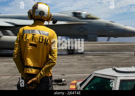 PHILIPPINE SEA (25. April 2022) Aviation Boatswain’s Mate (Handling) 1. Klasse Eric Arnold aus Durham, N.C., beobachtet den Flugbetrieb auf dem Flugdeck des Flugzeugträgers USS Abraham Lincoln (CVN 72) der Nimitz-Klasse. Die Abraham Lincoln Strike Group befindet sich im geplanten Einsatzgebiet der US-Flotte für 7., um die Interoperabilität durch Allianzen und Partnerschaften zu verbessern und gleichzeitig als reaktionsfähige Truppe zur Unterstützung einer freien und offenen Region im Indo-Pazifik-Raum zu dienen. (USA Navy Foto von Mass Communication Specialist Seaman Julia Brockman) Stockfoto