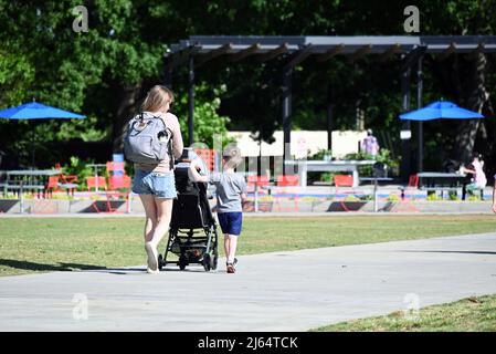 Eine Mutter geht mit ihrem kleinen Sohn in den Park in der Nähe der Innenstadt von Raleigh, North Carolina. Stockfoto