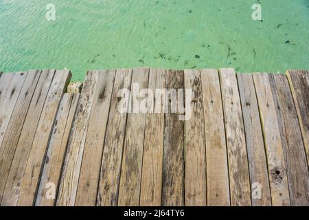 Leere braune Holzplattform neben tropischem Meeresstrand Sommerurlaub Stockfoto