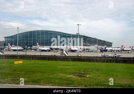 London, Großbritannien - 19. April 2022: Steht an einem sonnigen Frühlingmorgen im Hauptgebäude des Terminals 5 am Londoner Flughafen Heathrow voll mit British Airways-Flugzeugen Stockfoto