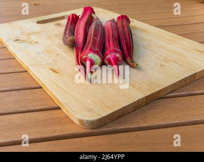 Frisch gepflückte Okra, eine Grundnahrungsmittel in der südlichen Küche wie Gumbo. Okra wächst in den USA gut. Die rosafarbenen essbaren Samenschoten sind Jing orange okra. Stockfoto