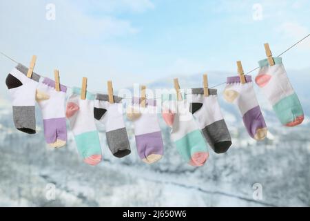 Seil mit sauberen Socken im Freien am Wintertag Stockfoto