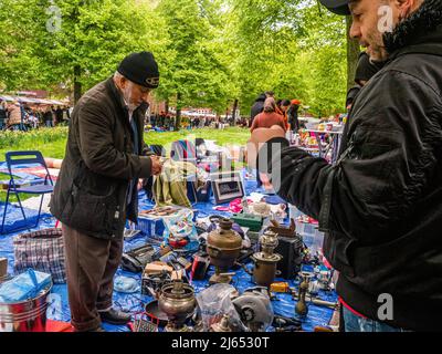 Amsterdam, Niederlande. 27. April 2022. Ein Mann wird gesehen, wie er alte Sachen von einem der freien Marktstände kauft. Nach zwei Jahren der Beschränkungen, gingen die diesjährigen Feierlichkeiten zum Königstag wieder normal. Der King's Day ist bekannt dafür, eines der größten und buntesten Feste des Landes zu sein, vor allem in Amsterdam. Die Stadt strotzt vor Orange, während die Menschen die größte Straßenparty des Jahres genießen, die freien Märkte genießen und Spaß auf den Booten entlang der Kanäle haben. (Foto: Ana Fernandez/SOPA Images/Sipa USA) Quelle: SIPA USA/Alamy Live News Stockfoto