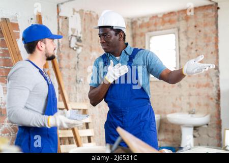 Vorarbeiter unzufrieden mit der Qualität der Reparaturarbeiten des männlichen Bauherrn Stockfoto