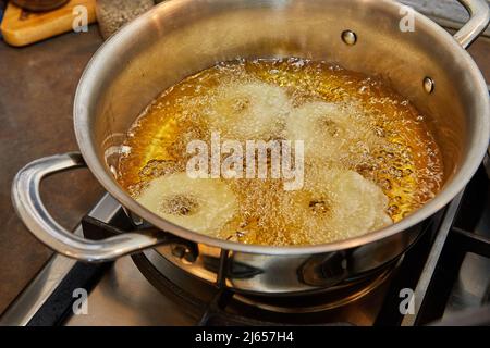 Kochen von Apfelpfannkuchen. Apfeldonut in kochendem Öl. Stockfoto