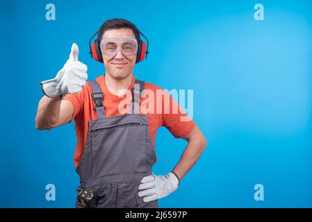 Stolzer Zimmermann gestikuliert den Daumen hoch und lächelt Stockfoto