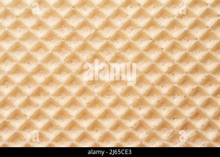 Abstraktes Relief goldene Waffelstruktur, Hintergrund für Ihr Design. Süßes, leckeres Dessert. Nahaufnahme mit Zelltextur. Knusprig geröstete Waffeloberfläche Stockfoto