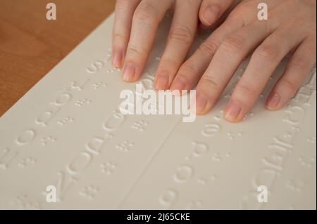 Eine Frau lernt das Braillealphabet mit einem Decoder. Stockfoto