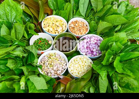 Miang Kham oder wilde Betelblätter wickeln Zutaten mit Zitronengras, Knoblauch, Schalotte, Limette, Chili, Geröstete Erdnüsse mit süßer Dipping-Sauce, asiatische Appe Stockfoto