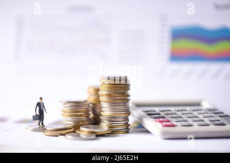 Gestapelte Münzen Finanz-und Business-Mann auf Business-Grafik Papier mit Rechner-Analyse von Business-Investment-Konzept Geld Stockfoto