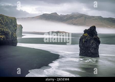 Arnardrangur, oder Eagle Rock, in Dyrholaey, Südisland. Das Gestein wird so genannt, weil Adler es früher nisten. Zusammensetzung der Langzeitbelichtung mit R Stockfoto