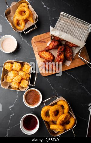 Der Bierteller mit würzigen Hähnchenflügeln, Calamari-Ringen, Pommes-Zwiebelringen, Käsebällchen, Kartoffeln, Paniert Stockfoto