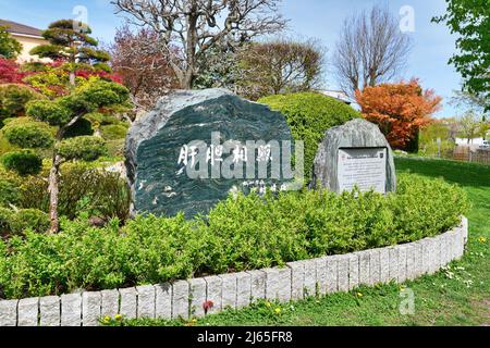 Freiburg, Deutschland - April 2022: Gedenkstein mit Inschrift im japanischen Garten im öffentlichen Park Seepark Stockfoto