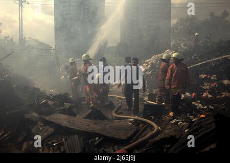 Mitglieder der Löschgruppe von Jakarta, die die Abkühlphase nach einem Feuerunfall durchführten, verbrannten Lagergebäude einer Heimindustrie in Kebayoran Lama, Süd-Jakarta, Jakarta, Indonesien. Stockfoto