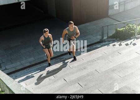 Sportliches Paar beim Training, Treppenlauf im Freien Stockfoto