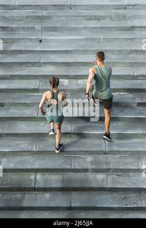 Sportliches Paar beim Training, Treppenlauf im Freien Stockfoto